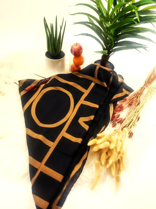 Premium black scarf with gold geometric design. Versatile, lightweight, and perfect for elevating any outfit.